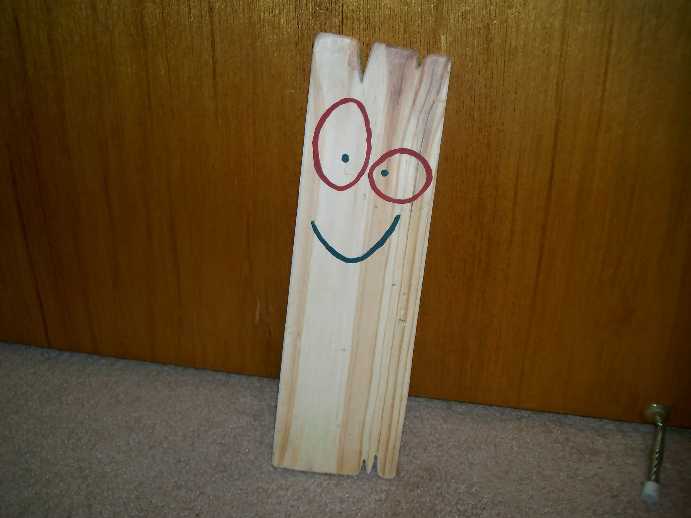 Plank, a smiling wooden board — the official mascot and Editor-in-Chief of The Butt Board